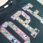 Close-up of floral fabric inside OPE appliqué on teal