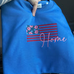 Close-up of floral American flag and Home lettering on blue fabric