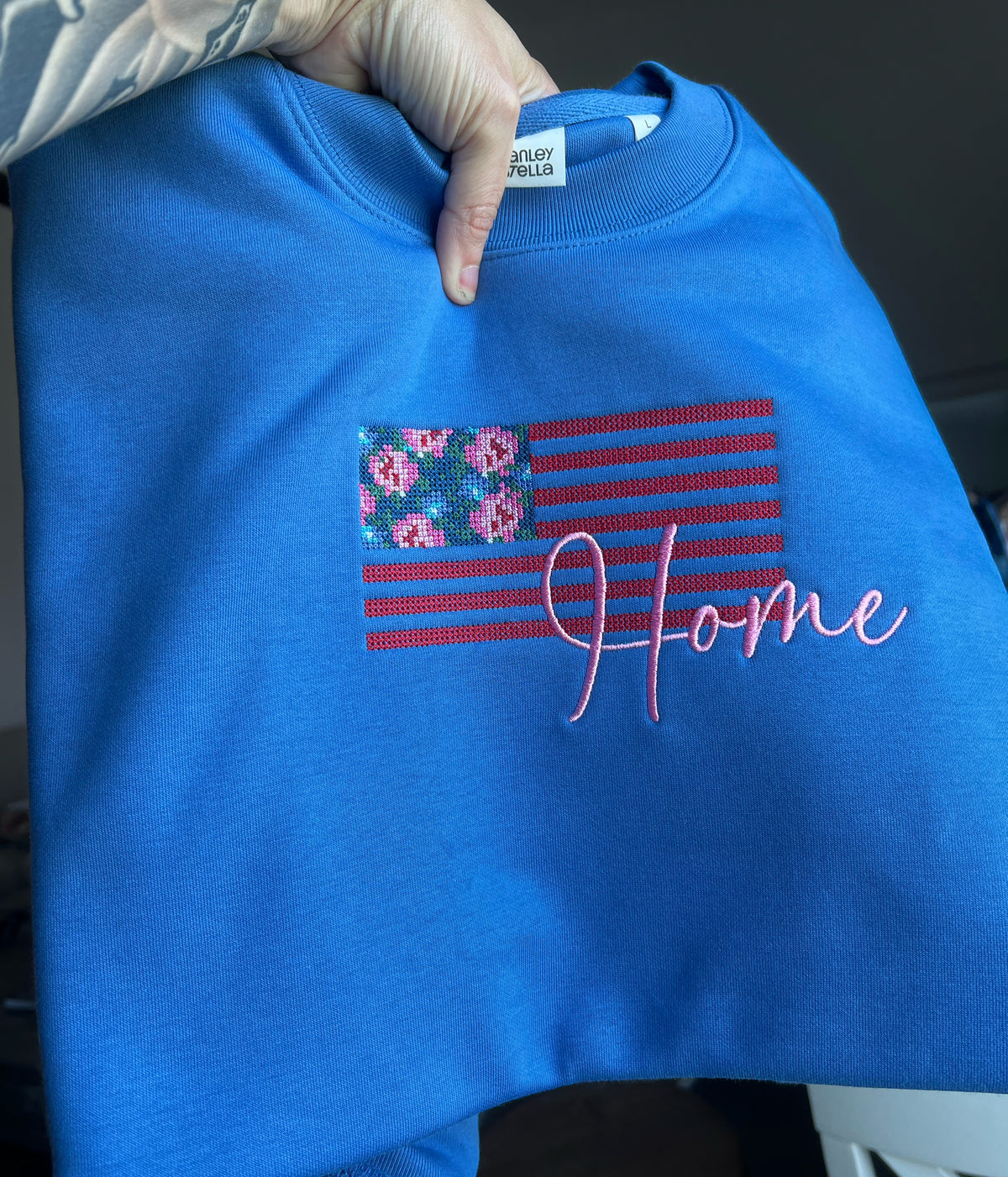 Close-up of floral American flag and Home lettering on blue fabric