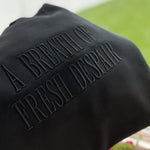 Black embroidered Breath of Fresh Despair sweatshirt on hanger