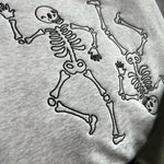 Close-up of dark skeleton stitching on gray fabric