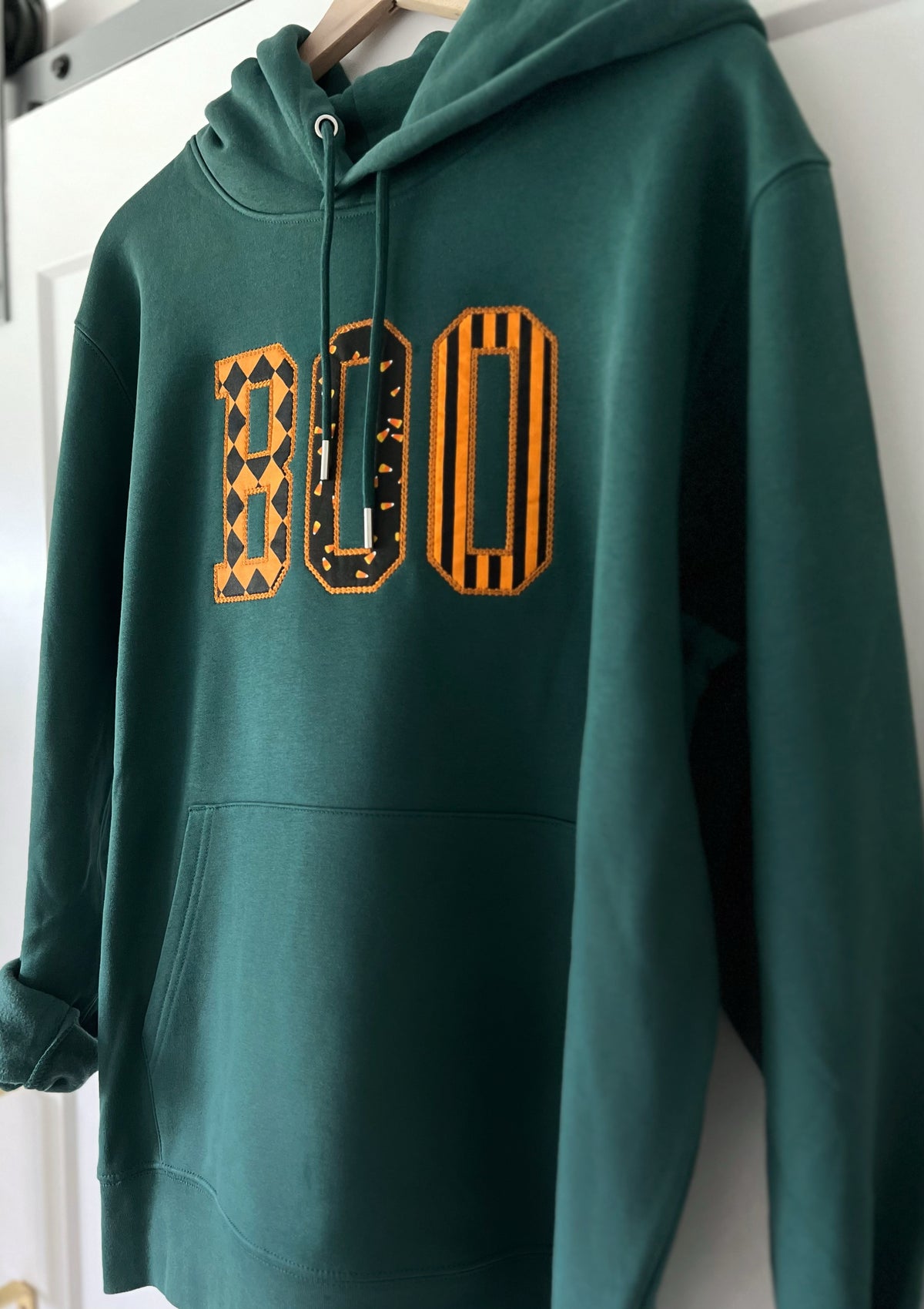 Green BOO appliqué hoodie on a hanger