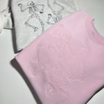 Gray and pink skeleton sweatshirts beside olive joggers