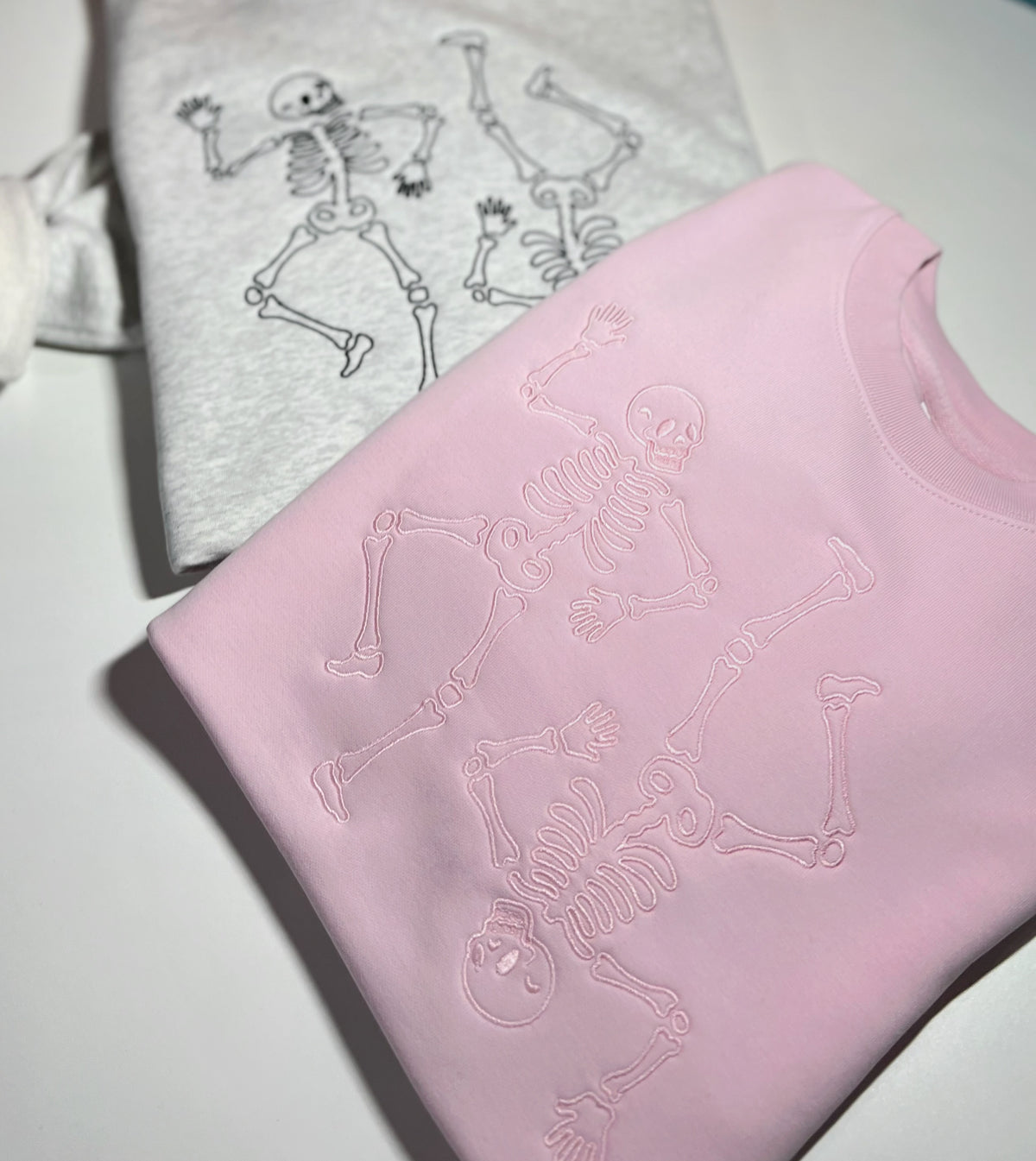 Gray and pink skeleton sweatshirts beside olive joggers