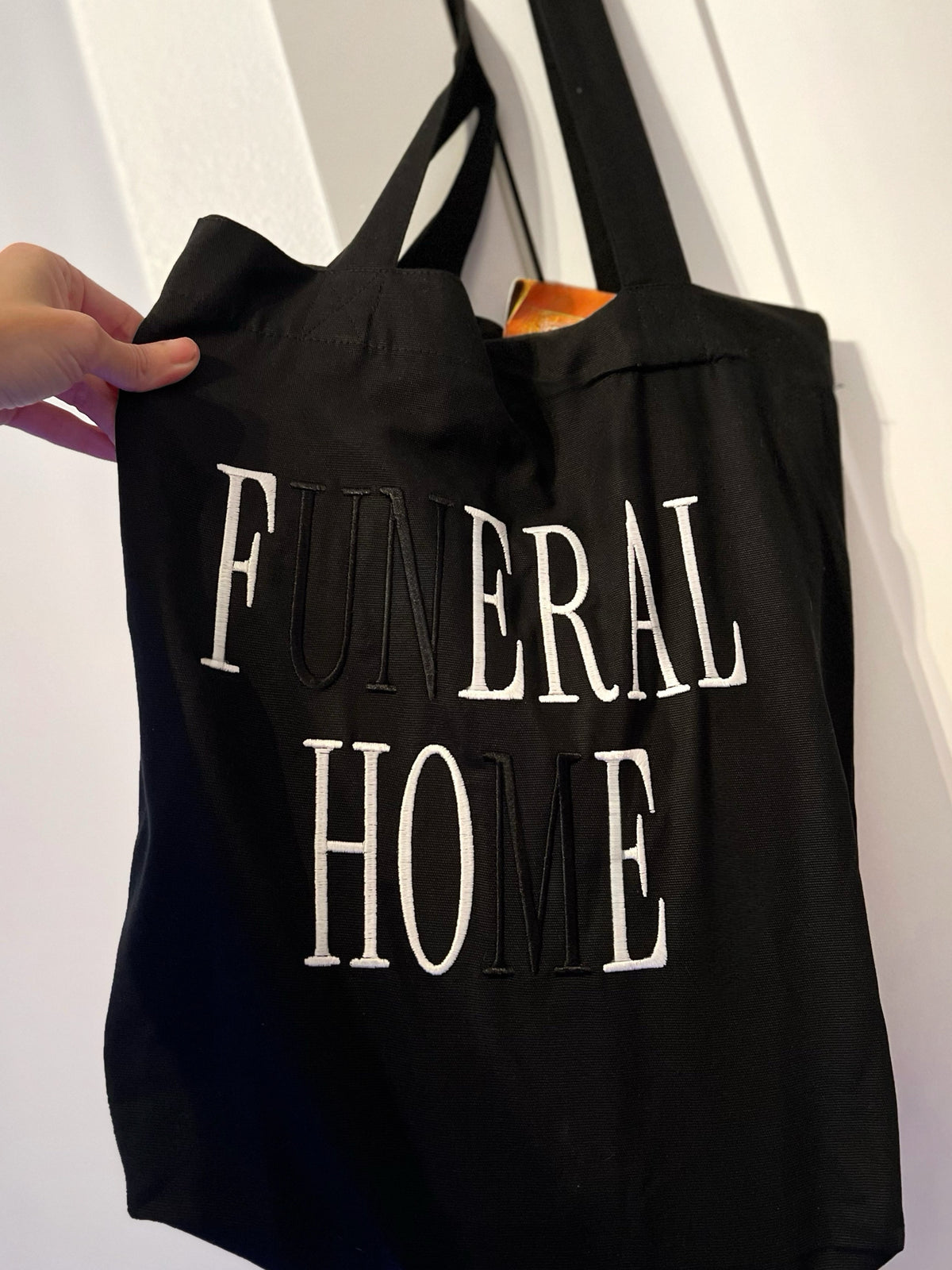 Black tote bag with Funeral Home and Feral Hoe embroidery