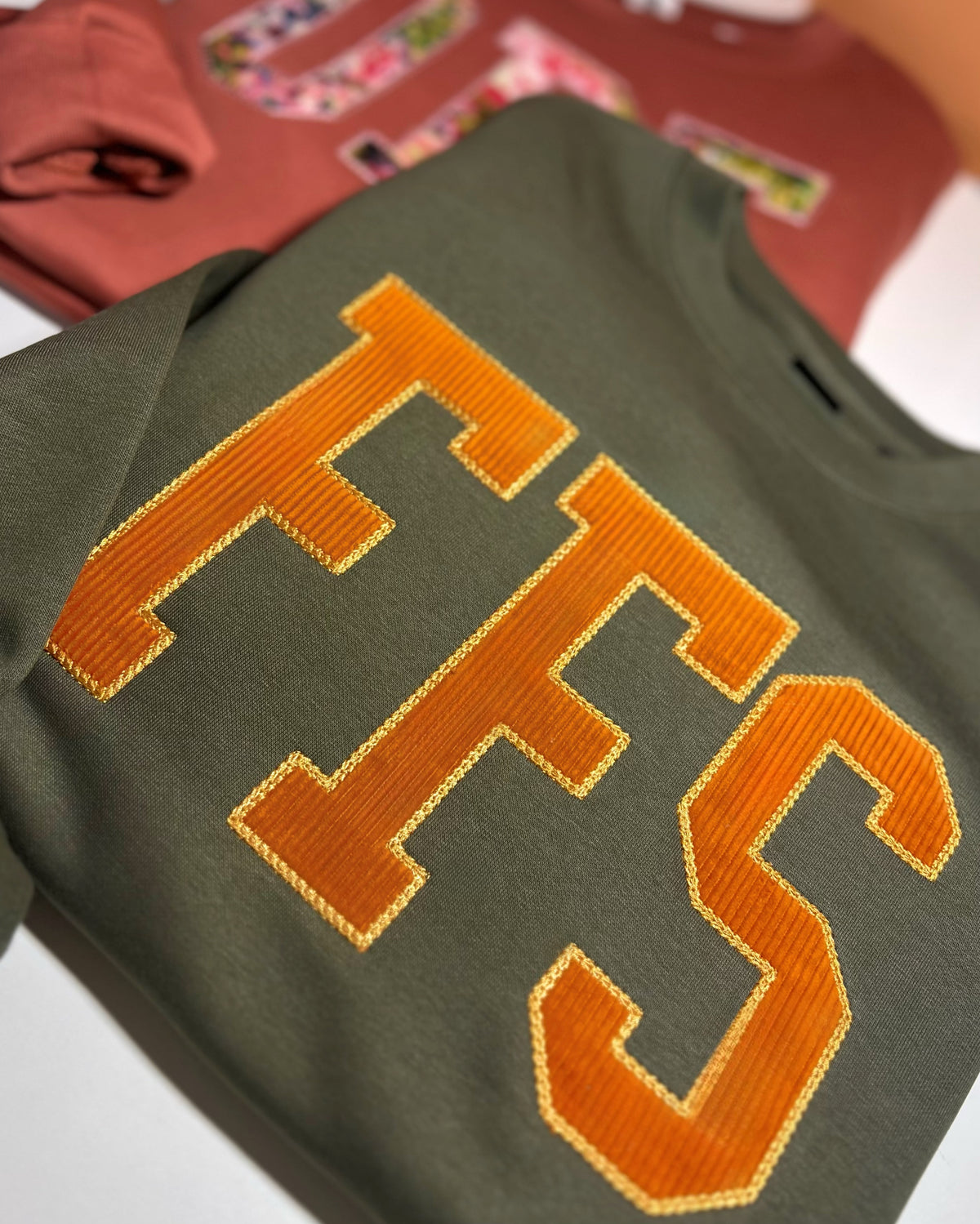 Dark sweatshirt with orange corduroy FFS appliqué