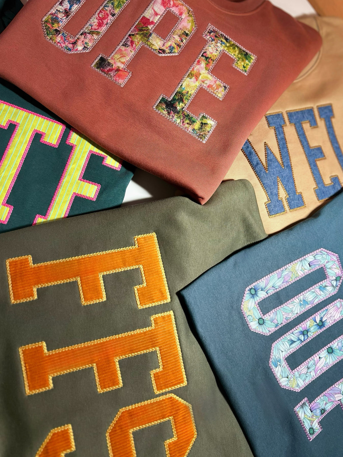 Assorted custom appliqué sweatshirts with OPE, FFS, and WTF letters