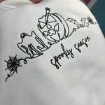 Close-up of embroidered ghost, pumpkin, bats, and spiderwebs