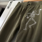 Olive joggers with two embroidered skeletons