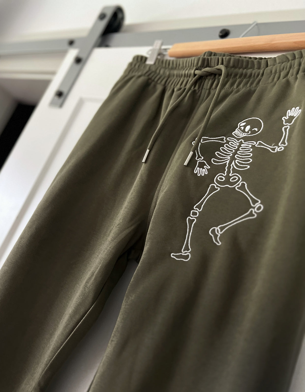 Olive joggers with two embroidered skeletons
