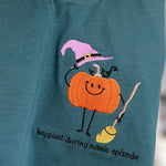 Close-up of pumpkin with broom and embroidered caption